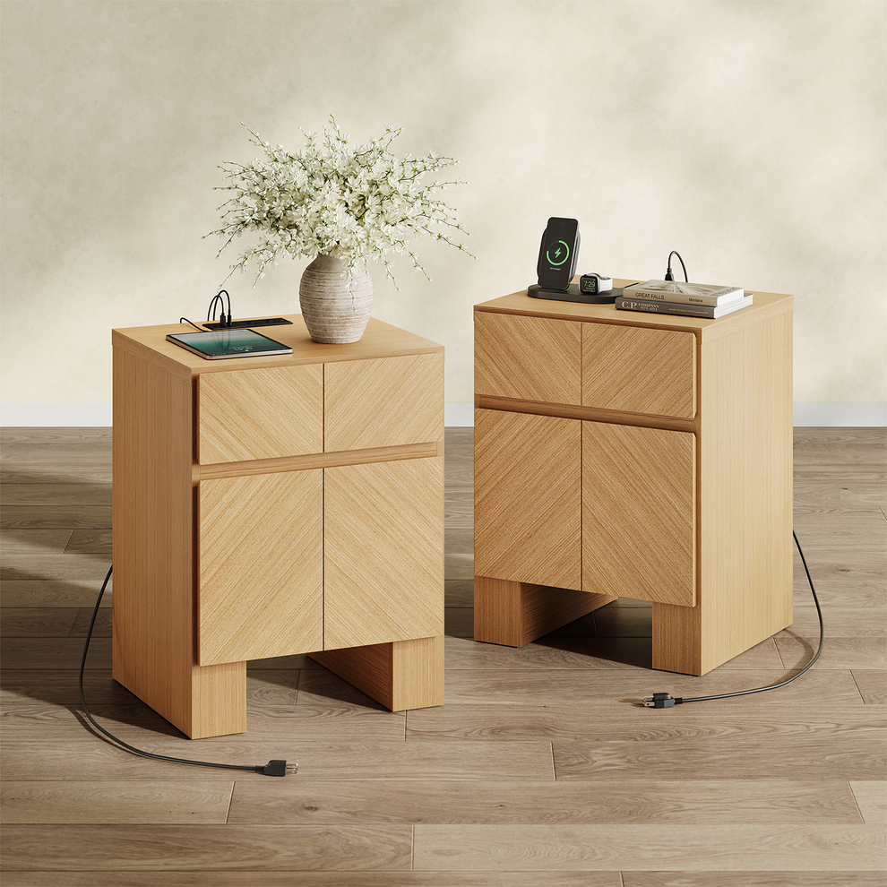 Two light wood cabinets have four handleless panels, open bases, and top-mounted power strips with connected devices