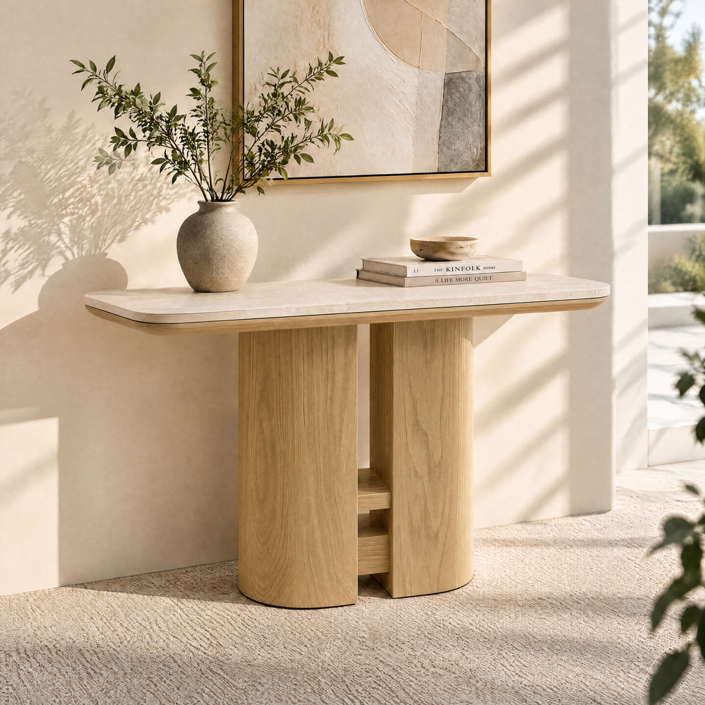 Light wood console table with a pale stone top, styled with a vase and books.