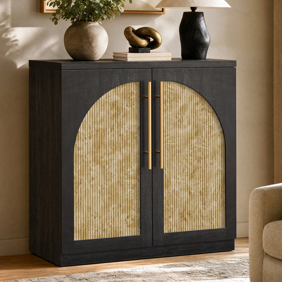 Black wood-grain cabinet with pale mottled arched fluted door panels and gold-tone handles in a living room