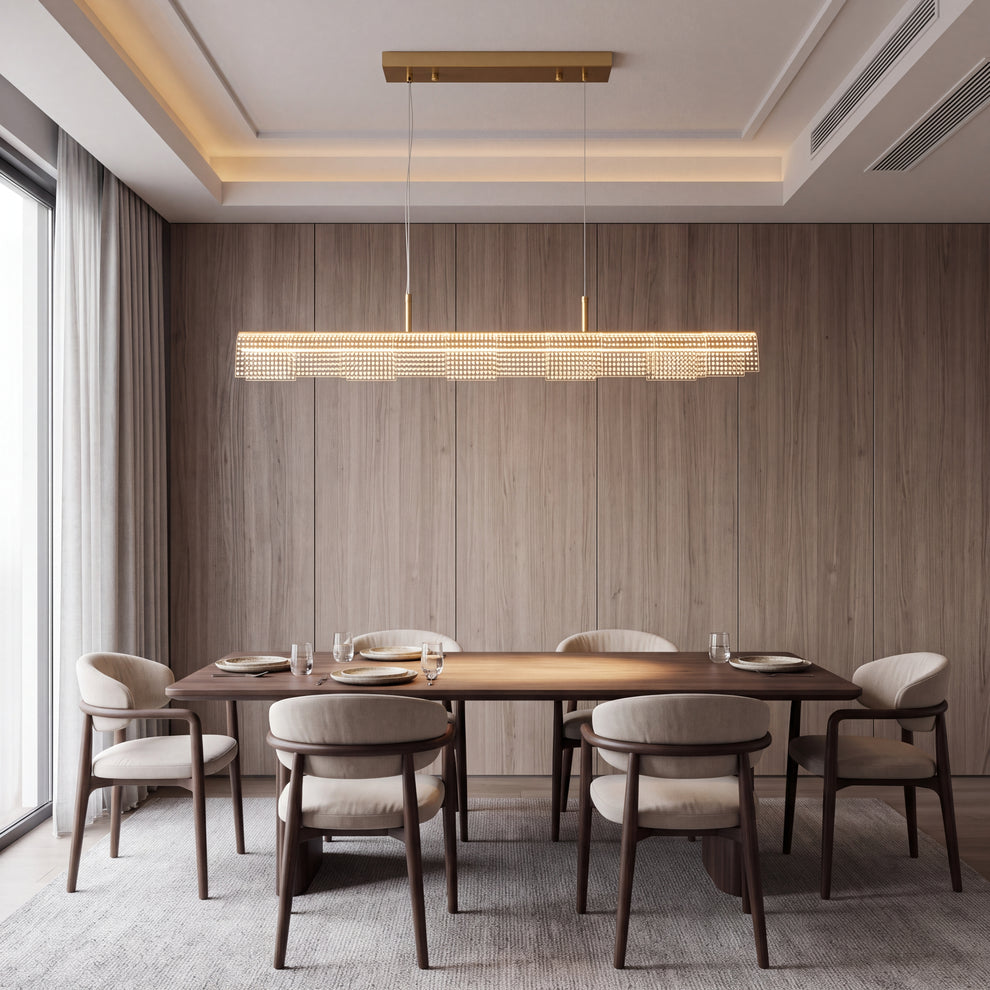 A long illuminated pendant with rows of bright dots hangs over a dining table set with plates and glasses, surrounded by six upholstered chairs against a paneled wall.