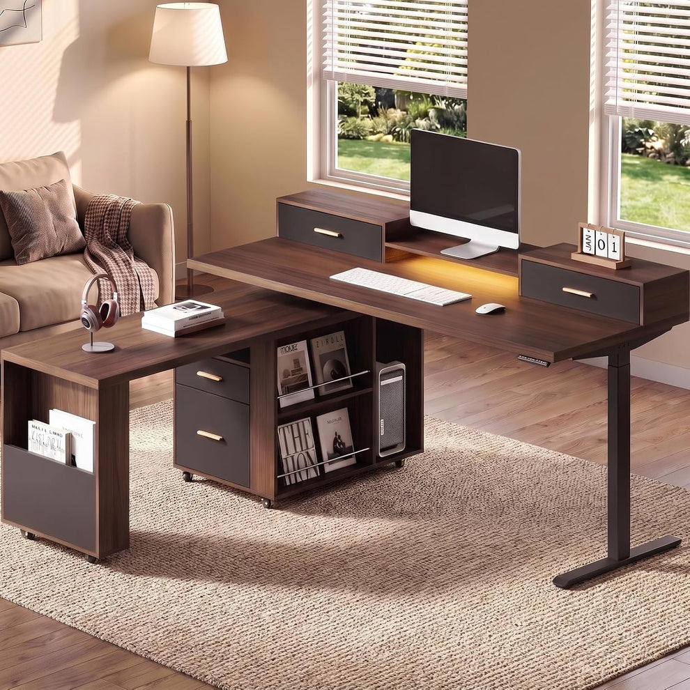 A dark wood L-shaped desk with drawers and shelves holds a monitor, keyboard, mouse, and headphones in a sunlit room.