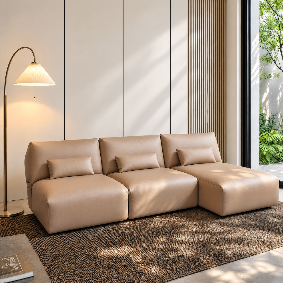Tan three-seat modular sofa with matching lumbar pillows in a bright modern room