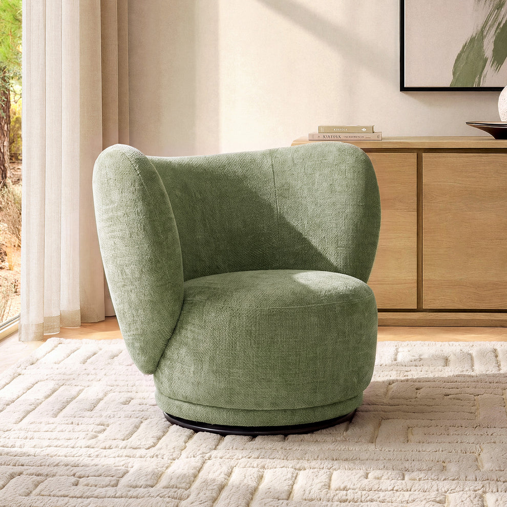 Diagonal sunlight crosses a green chair with a curved wraparound back and rounded seat