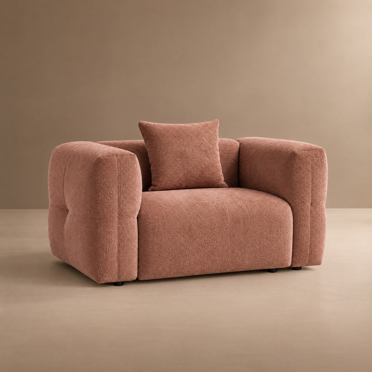 Dusty rose upholstered armchair with rounded arms and a matching square pillow.