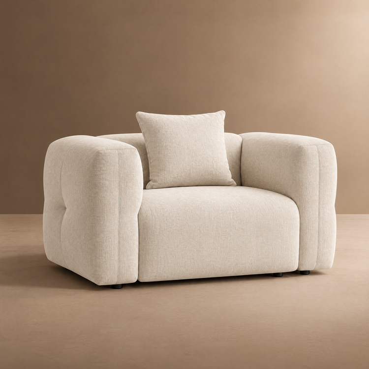 Cream upholstered armchair with rounded arms and a matching square cushion.