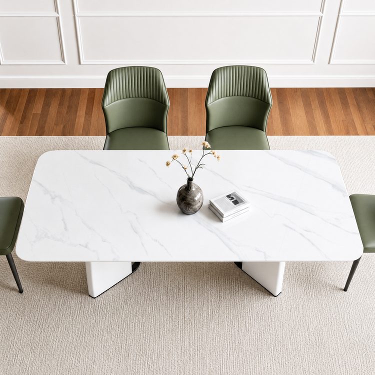 White veined dining table with rounded corners and geometric pedestal supports, viewed from above with green chairs