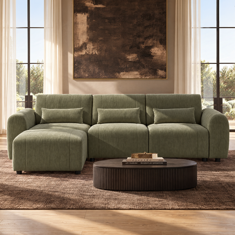 Olive-green sectional sofa with three cushions and a left-side chaise sits beneath a large abstract painting, between tall windows.