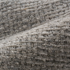 Close-up of gray woven fabric with thick, fuzzy threads forming a textured grid and a diagonal fold.