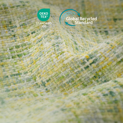 Close-up of folded, textured fabric woven in cream, yellow and green, with OEKO-TEX Standard 100 and Global Recycled Standard logos above.