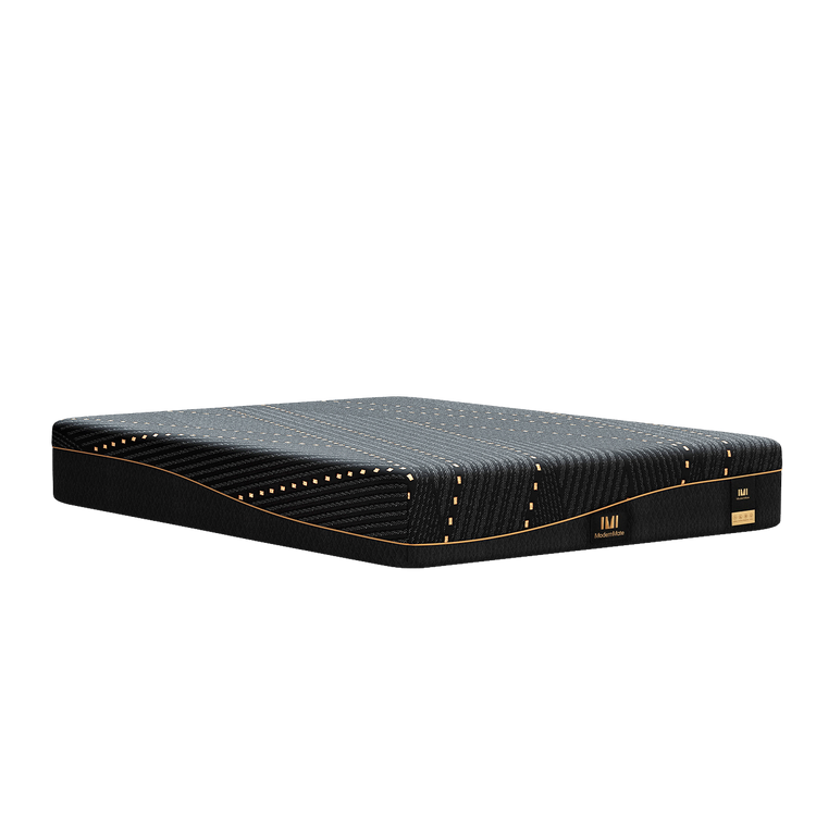 Low side profile of a black patterned mattress with gold piping on a white background