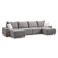 Gray sectional sofa with a chaise at each end and two white pillows.