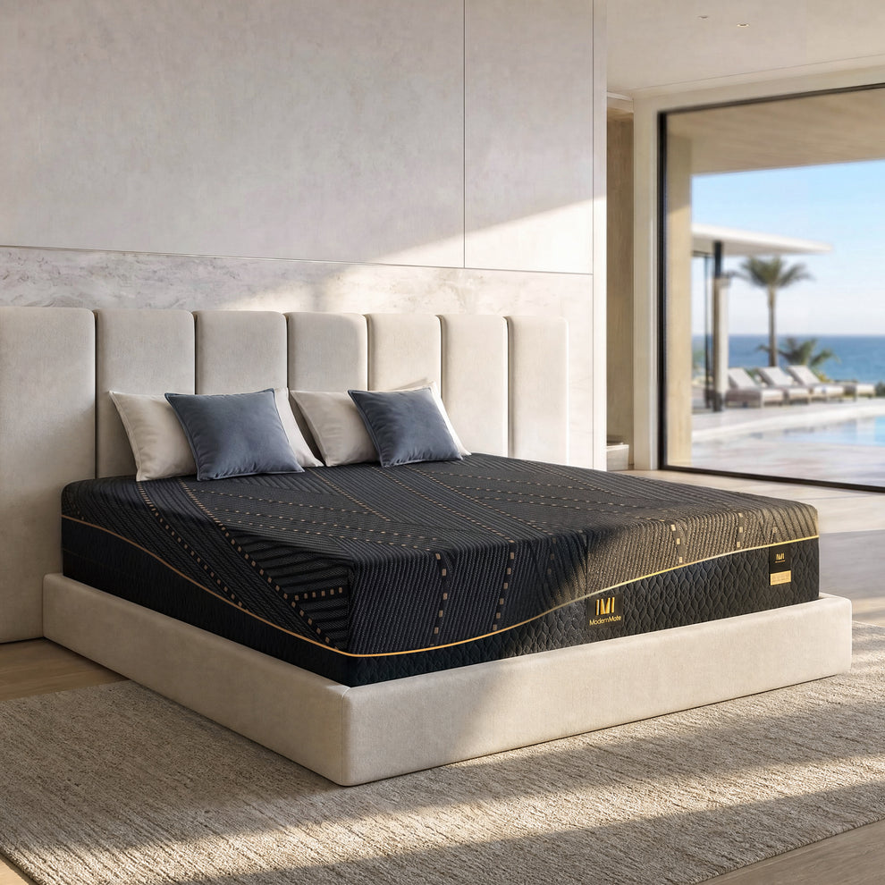Black patterned mattress with gold piping placed on a cream upholstered platform bed
