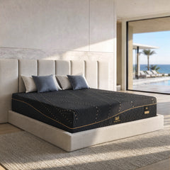 Dark patterned mattress rests on a light upholstered bed beneath a tall segmented headboard