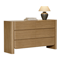 Wide light wood six-drawer dresser isolated on a black background with a lamp on top