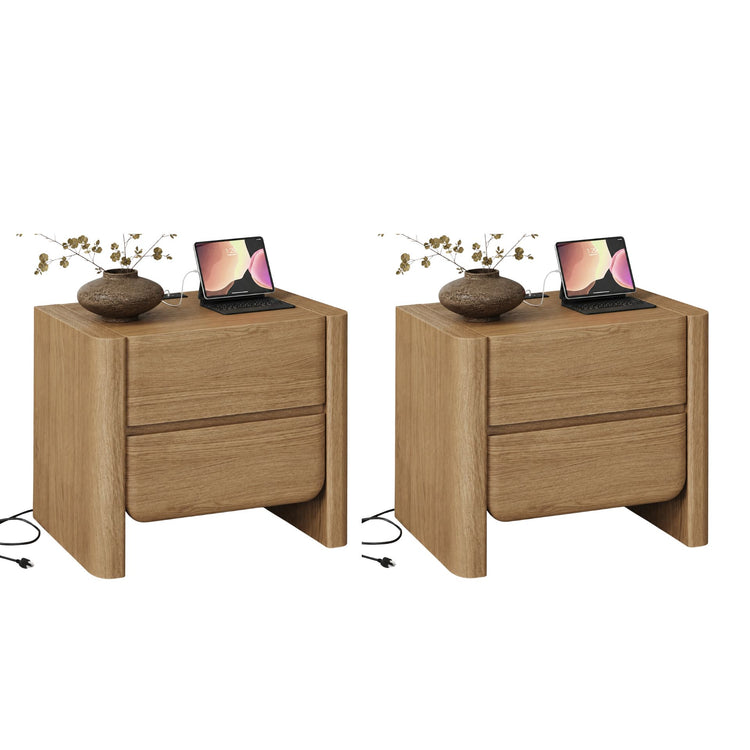 Two light wood two-drawer nightstands shown side by side, Each top holds a vase, tablet, keyboard, and cable
