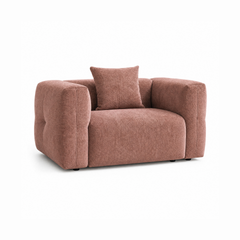Dusty rose upholstered armchair with wide padded arms and a matching back cushion.