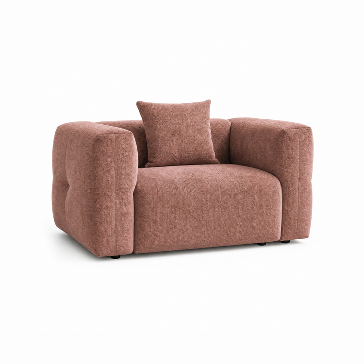 Dusty rose upholstered armchair with wide padded arms and a matching back cushion.