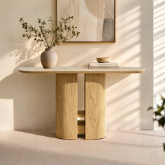 Light wood console table styled with a vase, books, and bowl in sunlight.