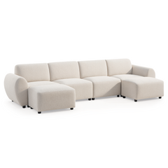 Cream-colored sofa with four back cushions, rounded arms and short black feet, with two matching ottomans positioned in front of the outer seats.