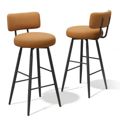 Two tan upholstered bar stools with slim black legs, footrests, and curved backs on white