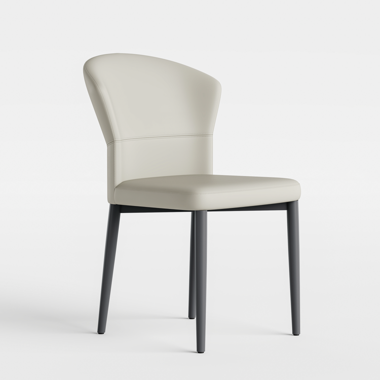 Pale upholstered armless chair has a curved back and four long dark tapered legs