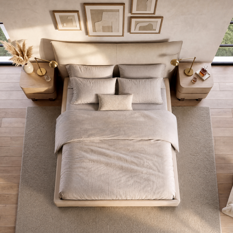 Neutral upholstered bed with layered pillows between matching wooden nightstands.