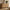 Light wood-grain six-drawer dresser with thick rounded side panels beneath a circular mirror