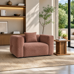 Rose upholstered armchair with matching cushion in a sunlit modern living room.