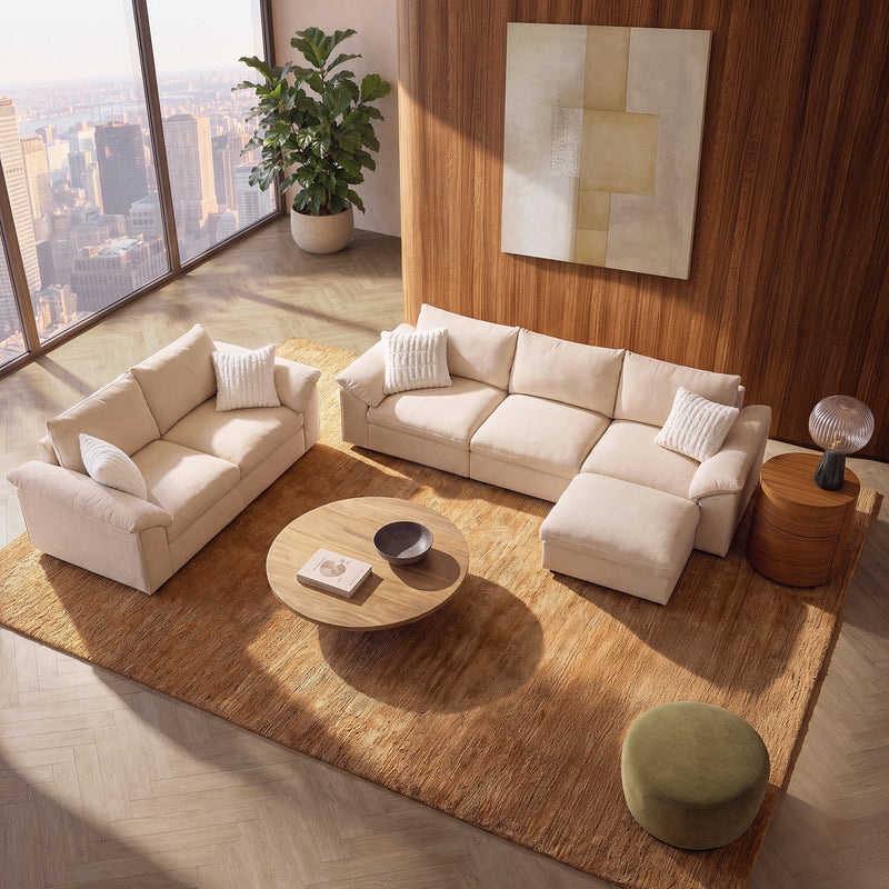 Beige modular sofa set with ottoman in a sunlit modern living room.