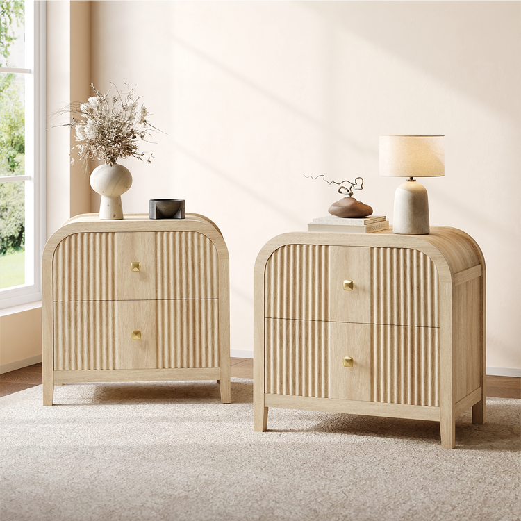 Two matching light wood-toned cabinets have rounded tops, fluted drawer fronts, and square gold-colored pulls