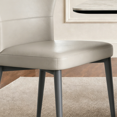 Light upholstered dining chair shown in a close detail view