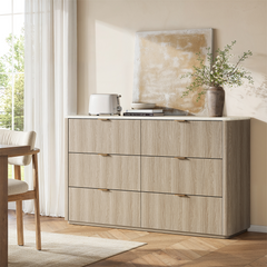 Light wood-toned dresser shown beneath wall art in a bedroom