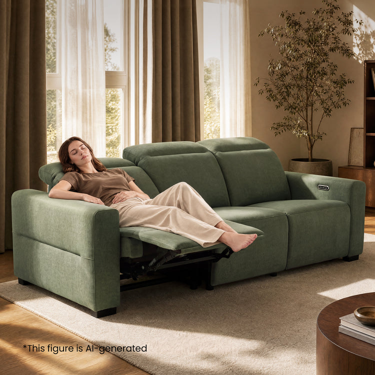 Woman resting on a green reclining sofa with the footrest extended.