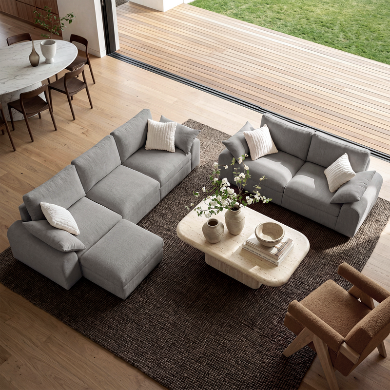 Gray modular L-shape and loveseat sofas arranged in a modern living room.