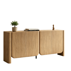 A four-door wood-grain sideboard with rounded lower corners is topped by a plant, books, and a small sculpture