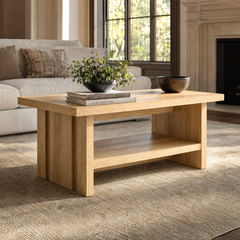 Wood-tone coffee table with an open lower shelf and grooved side panels in front of a sofa