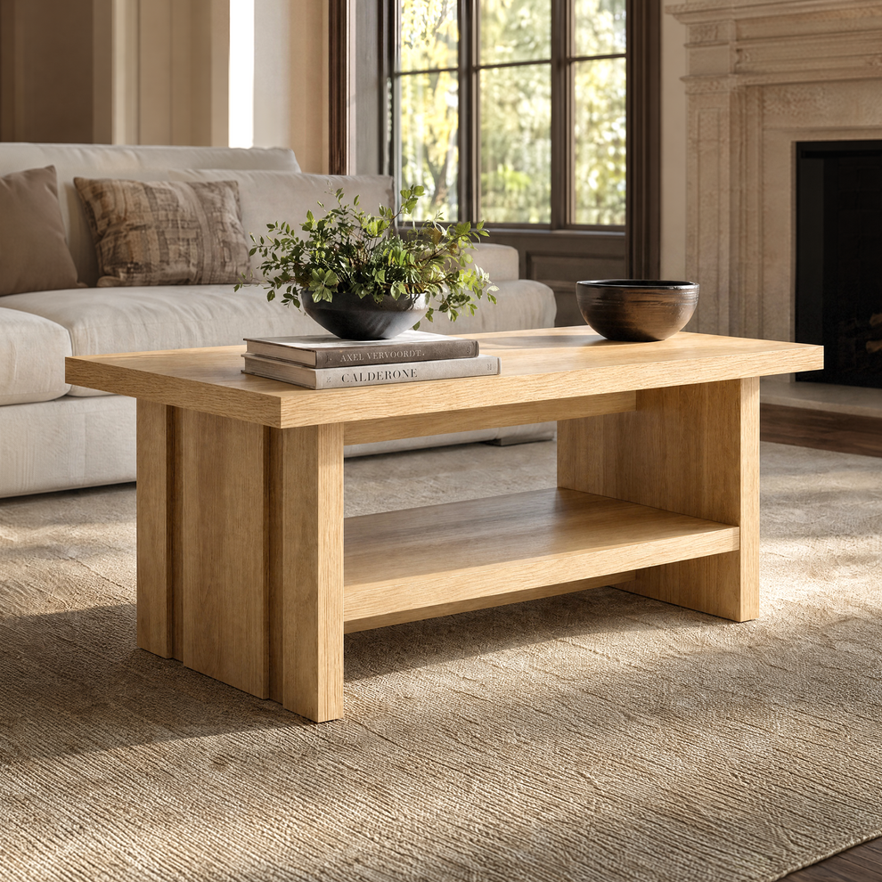 Wood-tone coffee table with an open lower shelf and grooved side panels in front of a sofa