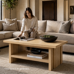 Light wood-grain coffee table with an open lower shelf in front of a seated reader holding a mug