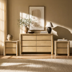 Light wood dresser and two nightstands form a coordinated furniture arrangement