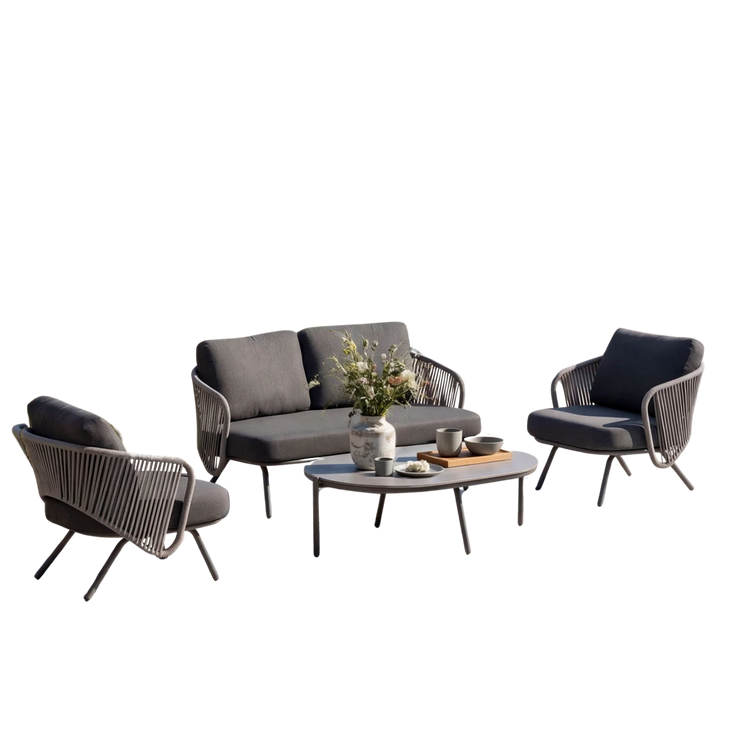 Cutout outdoor set with a sofa, two dark chairs, and a round coffee table on black