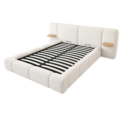 Cream upholstered bed frame with exposed black slats, padded panels and two attached wood-tone bedside shelves