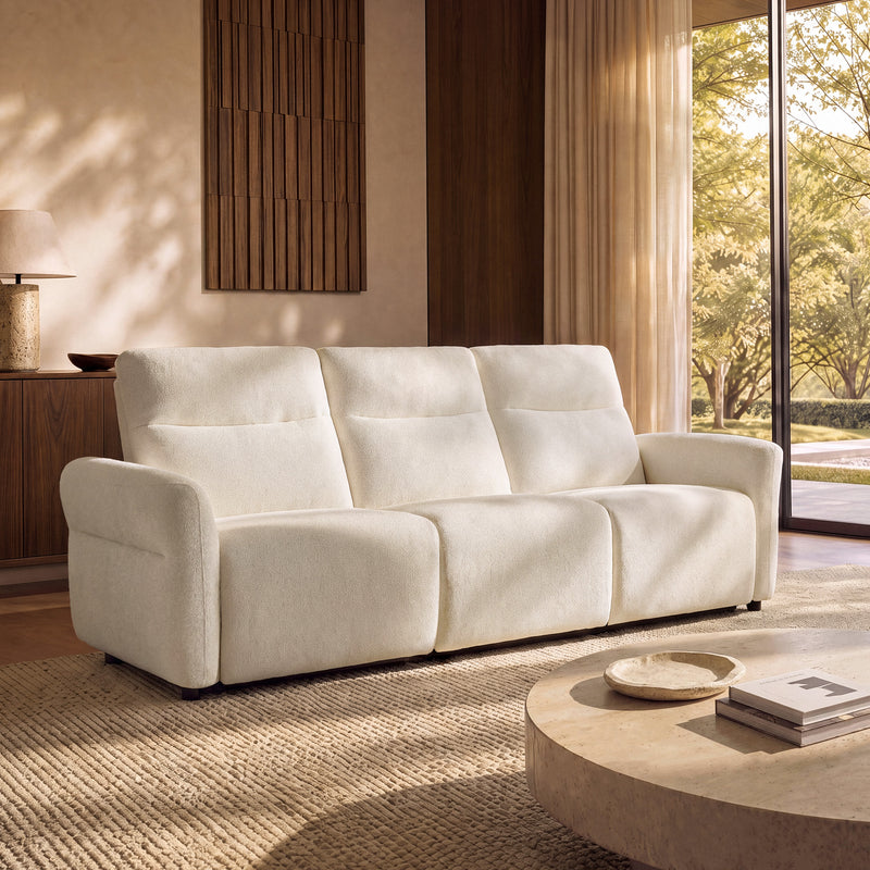 Beige textured three-seat sofa with padded backs and arms in a sunlit living room.