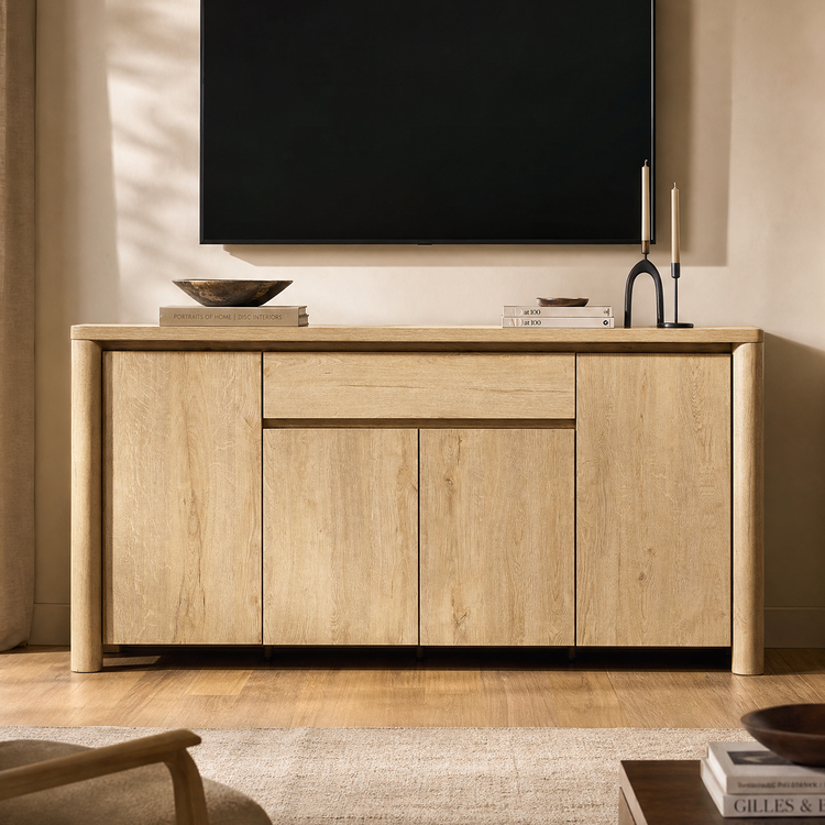 Light wood-tone accent cabinet with rounded corner posts and a central drawer beneath a wall-mounted television