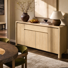 Light wood-toned sideboard has four lower doors, one wide upper drawer, and rounded corners