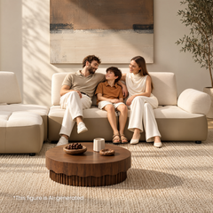 Two adults and a child seated together on a cream sectional sofa.