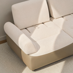 Cream upholstered two-seat sofa with broad back cushions and rounded armrests.