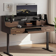 A wood-grain desk with drawers and a raised shelf holds a monitor, keyboard, controller, mouse, camera, and small decor.