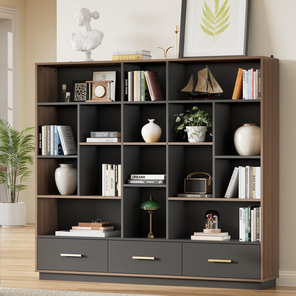 A charcoal cubby bookcase with brown trim stands against a wall, Three bottom drawers have slim gold-colored handles