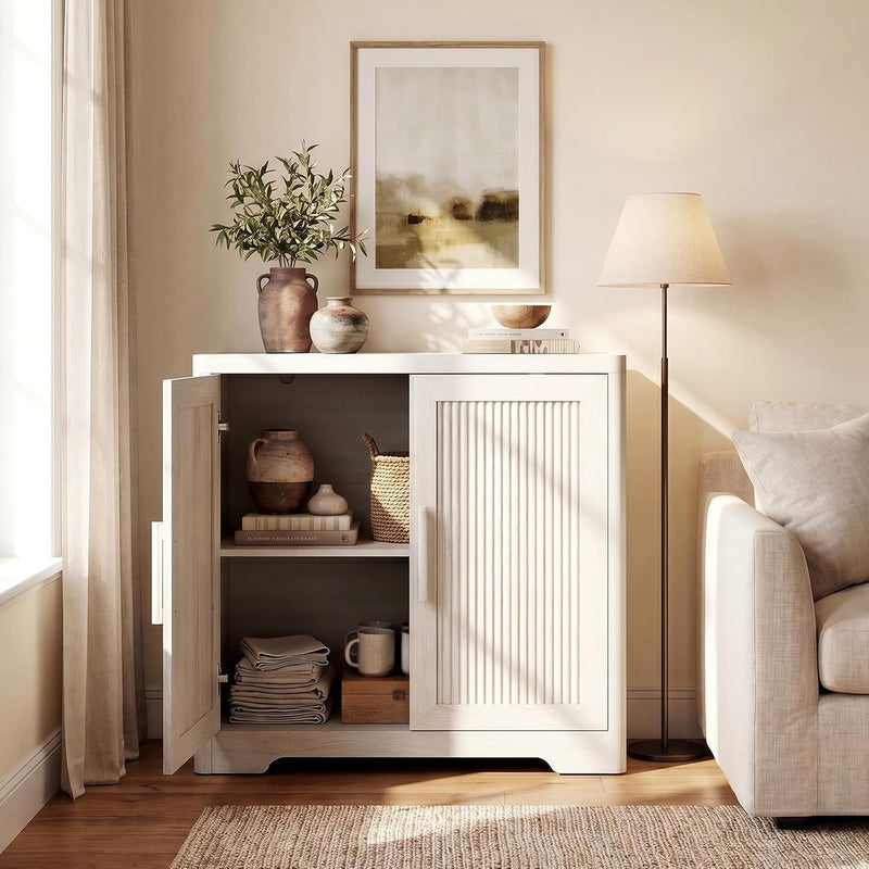 White reeded cabinet with one door open, displaying shelves in a styled living room.