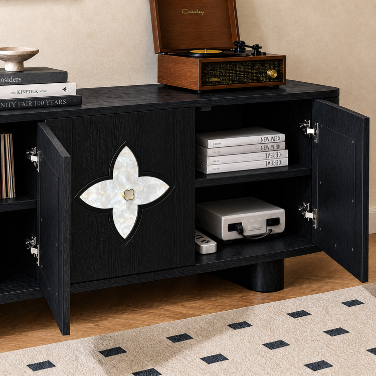 Black cabinet with open doors and a four-petal inlay holds books and a game console, with a wooden record player on top.